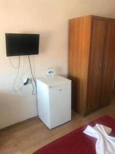 a small refrigerator in a room with a tv on the wall at bedesten otel in Amasra