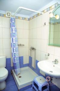 een badkamer met een douche, een toilet en een wastafel bij Karyatides Apartments in Kariá