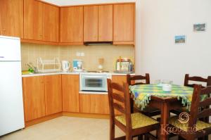 a kitchen with wooden cabinets and a table and a microwave at Karyatides Apartments in Kariá +6 photos