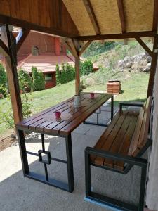 Zaovine的住宿－Vikendica moonlight，餐桌和凉亭下的长凳