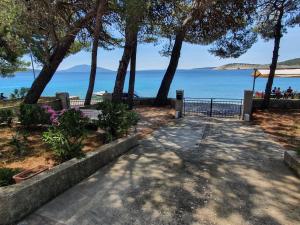 a walkway with trees and the ocean in the background at Sidus Maris, Spacious Seaside Apartment with Free Parking in Martinšćica