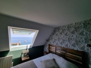 a bedroom with a bed and a window with the ocean at Hôtel Vauban in Le Palais