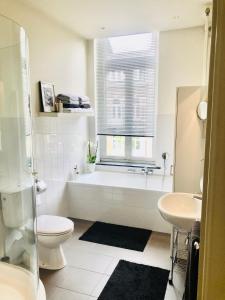 a bathroom with a tub and a toilet and a sink at B&B Alexander in Maastricht