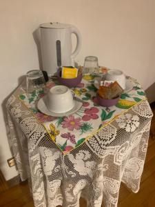 una mesa con un mantel con un set de té. en B&B Relax, en Miane