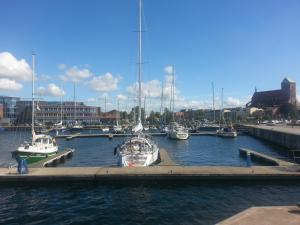 een groep boten is aangemeerd in een haven bij Pension Am Wassertor in Wismar