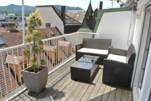 Un balcón con 2 sillas, una mesa y una planta en Esprit-Apart-Hotel en Baden-Baden