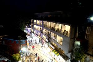 a group of people walking down a street at night at Hotel Hamers International in Mussoorie