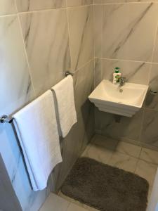 a bathroom with a sink and a white towel at Pomona Lodge in Kempton Park