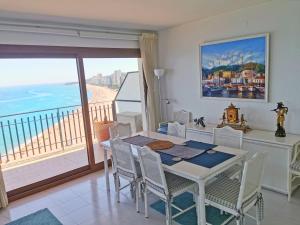 a dining room with a table and a view of the ocean at Spacious seafront apartment in Platja d'Aro