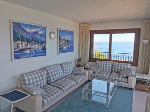 a living room with couches and a view of the ocean at Spacious seafront apartment in Platja d'Aro