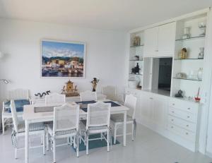 un comedor blanco con una mesa y sillas blancas en Spacious seafront apartment, en Platja d'Aro
