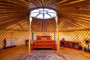 een grote yurt met een bed en een raam bij Purling Brook Falls Gwongorella in Springbrook