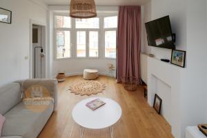 a living room with a couch and a table at Appartement La Cabane in De Panne