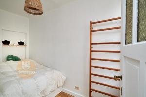 een kleine slaapkamer met een bed en een deur bij Appartement La Cabane in De Panne