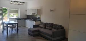 a living room with a couch and a kitchen at Stara Mleczarnia in Radków