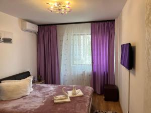 ママイア・ノルドにあるHoliday Beach 120mのベッドルーム1室(紫色のカーテン、靴付きのベッド1台付)