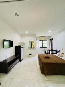 um quarto grande com uma cama e uma televisão em Wassana Sitdharma Guesthouse em Ban Na Pho