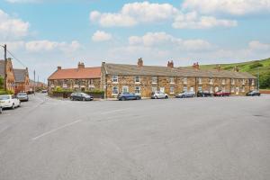 a large parking lot with cars parked in front of a building at Poets Cottage in Skinningrove