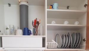 a cabinet filled with dishes and utensils at Stamatiou Dimitris in Methana