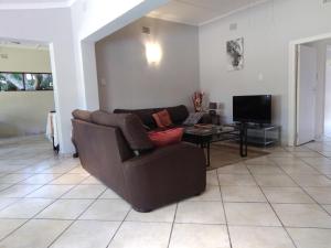 - un salon avec un canapé brun et une télévision dans l'établissement Parkers Cottages, à St Lucia