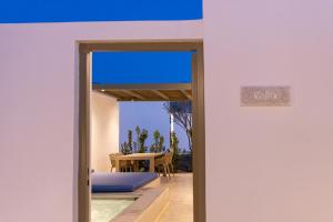 eine Tür, die auf eine Terrasse mit einem Tisch führt in der Unterkunft White Holidays Project in Tinos