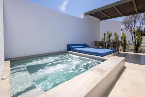 a large plunge pool in a house with a chair at White Holidays Project in Tinos Town