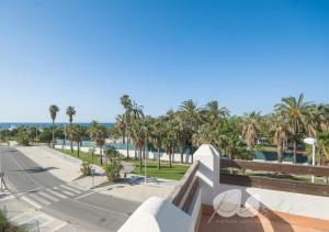 vista su una strada con palme e sull'oceano di PUSHE Village Playa Granada Beach & Golf 1 a Motril