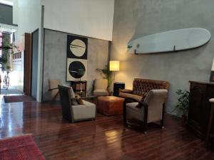a living room with chairs and a surfboard on the wall at Caruma Surf Hostel in Matosinhos