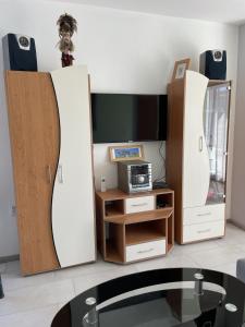 een woonkamer met twee witte kasten en een tv bij Pearl Sunshine Appartments in Primorsko