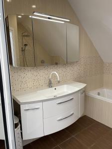 een badkamer met een wastafel, een spiegel en een bad bij Pearl Sunshine Appartments in Primorsko