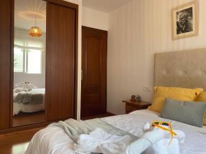 sypialnia z łóżkiem i dużym lustrem w obiekcie apartamento plaza del parque w mieście Villanueva de Arosa