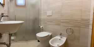 un piccolo bagno con un water e un lavandino di Appartamenti Alba e Tramonto a Marina di Mancaversa