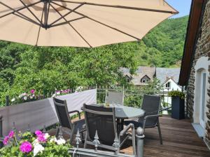eine Terrasse mit einem Tisch, Stühlen und einem Sonnenschirm in der Unterkunft Ferienwohnung Fritzer in Ellenz-Poltersdorf
