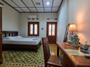 a bedroom with a bed and a table and a desk at Omah Pitoe Yogya Homestay in Yogyakarta