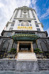 un edificio blanco alto con un reloj en él en MADELISE HOTEL&APARTMENT, en Hai Phong