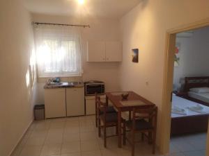 a kitchen and dining room with a table and chairs at KANALI HOLIDAYS APARTMENT 2 in Kanali
