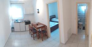 a small kitchen with a table and chairs in a room at KANALI HOLIDAYS APARTMENT 2 in Kanali