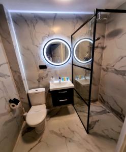 a bathroom with a toilet and a sink and a mirror at Villa Justyna in Pobierowo
