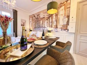 uma sala de jantar com uma mesa com garrafas de vinho em La Marquise - Cosy Flat - Jacuzzi - Senlis em Senlis