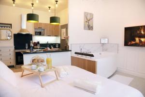 a living room with a white couch and a kitchen at La Marquise - Cosy Flat - Jacuzzi - Senlis in Senlis