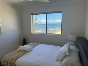 a bedroom with a bed with a view of the ocean at Beachfront Penthouse at The Entrance in The Entrance