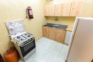 een kleine keuken met een fornuis en een koelkast bij العييري للوحدات المفروشة الباحة3 in Al Baha