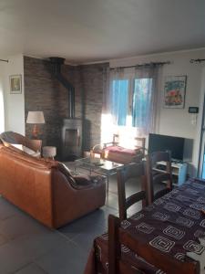 a living room with leather furniture and a fireplace at Le devezou Malons et Elze in Malons-et-Elze
