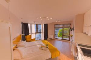 a bedroom with a large bed with a yellow blanket at B&P studios in Varna City