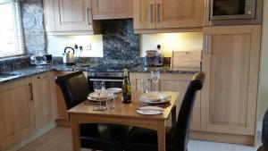 eine Küche mit einem Holztisch mit Weingläsern darauf in der Unterkunft Ty Derw Country House B&B in Ruthin