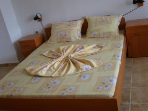 a bedroom with a bed with a flower comforter at Сотирови, самостоятелни стаи in Chernomorets