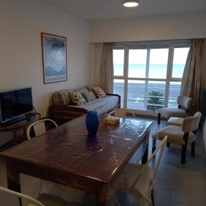 sala de estar con sofá y mesa con sillas en Ventana al Mar en Puerto Madryn