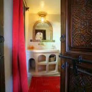 bagno con specchio e tenda rossa di Riad Cafe Du Sud a Lac Yasmins