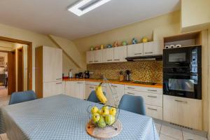 una cocina con una mesa con un bol de fruta. en séjour 6 pers.( atypique ) f4 110 m2, en Houssen