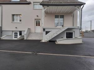 una casa blanca con escaleras en un aparcamiento en séjour 6 pers.( atypique ) f4 110 m2, en Houssen